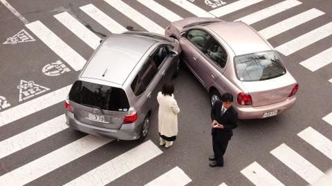 Cars crash in a minor collision at an intersection.